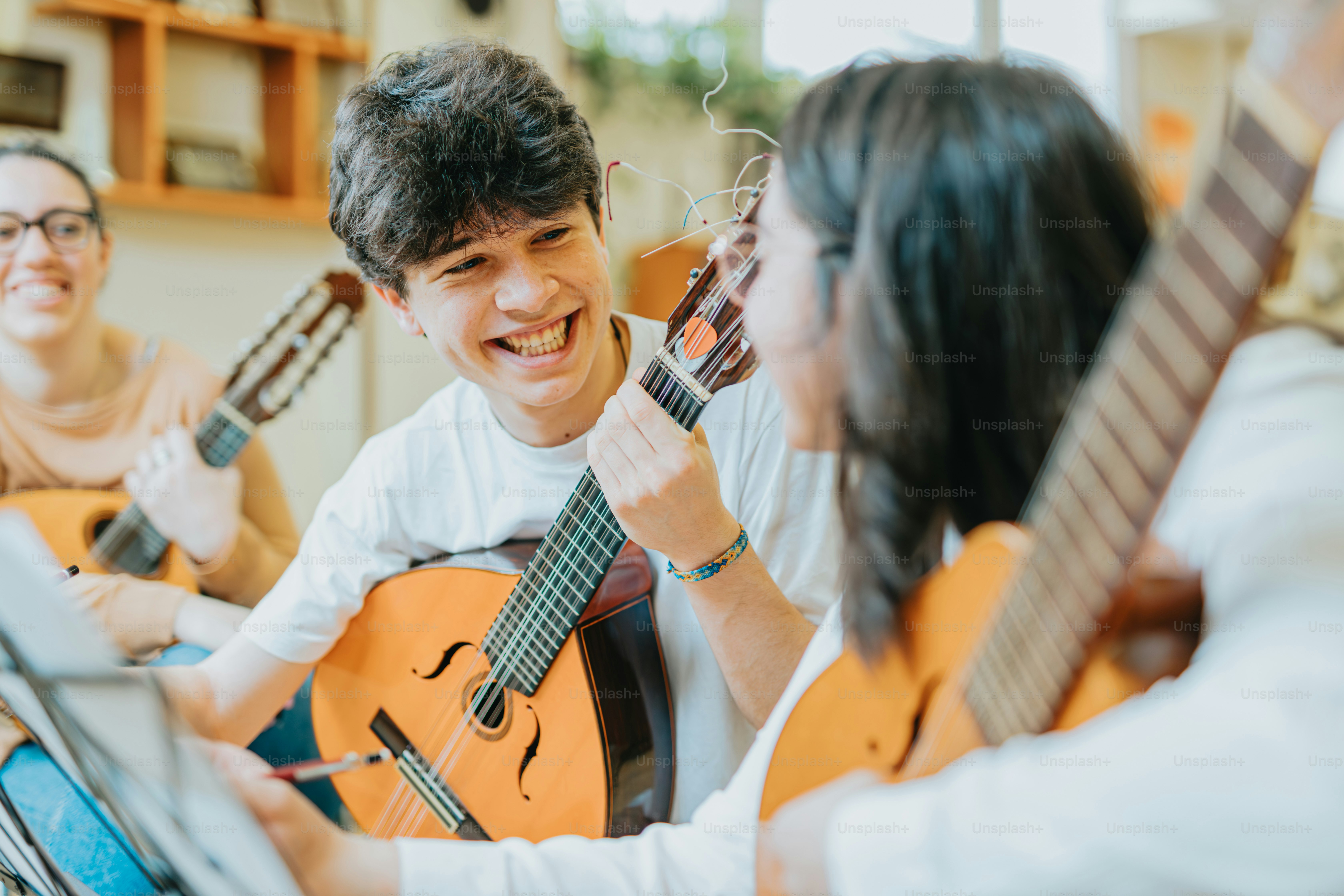 a group of people sitting around each other playing guitars