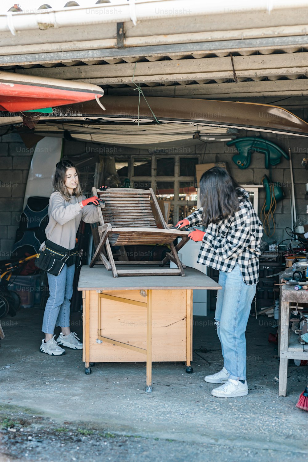 a couple of women working on something in a garage