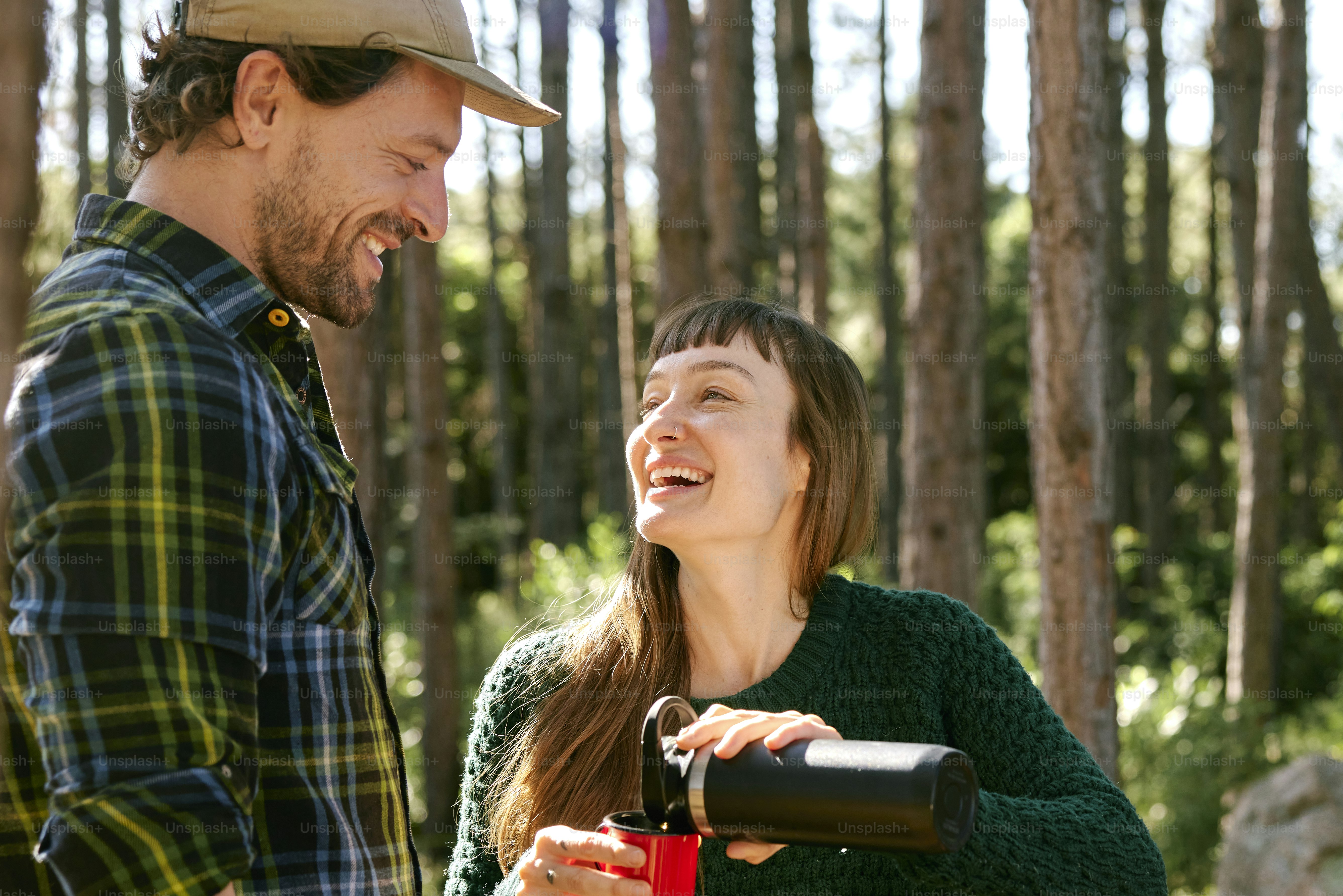 a man standing next to a woman in a forest
