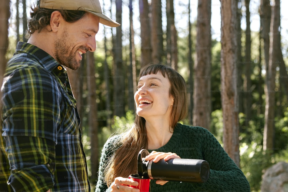 a man standing next to a woman in a forest