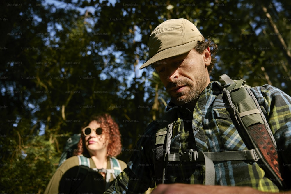 a man and a woman standing in front of trees