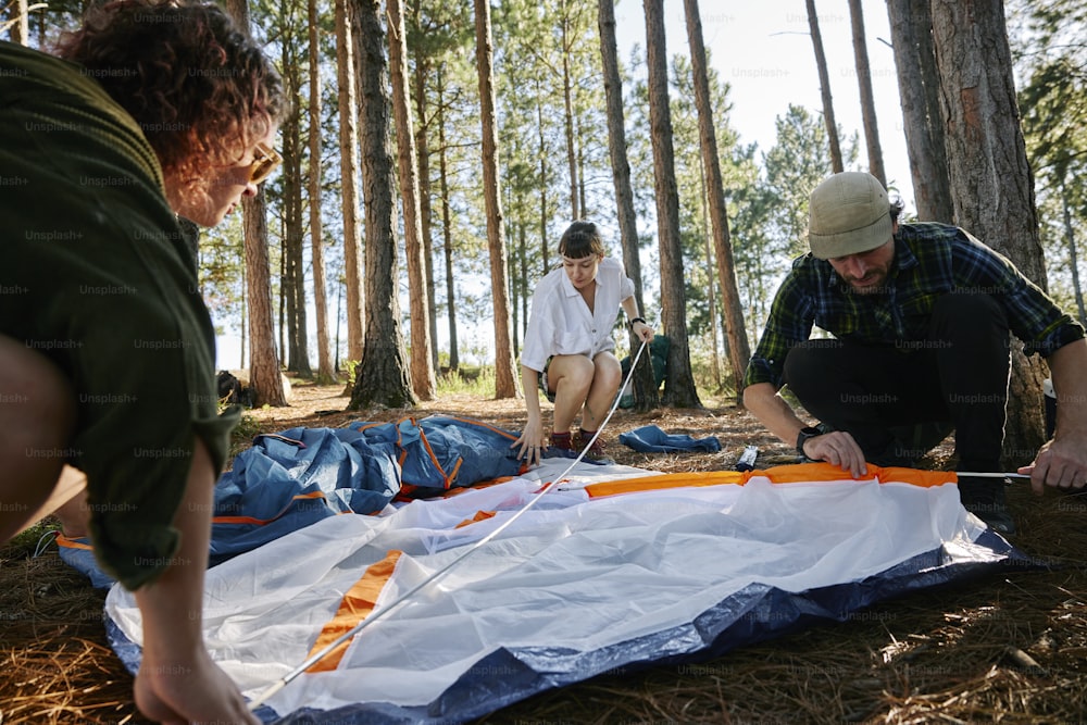 a group of people preparing a kite in the woods