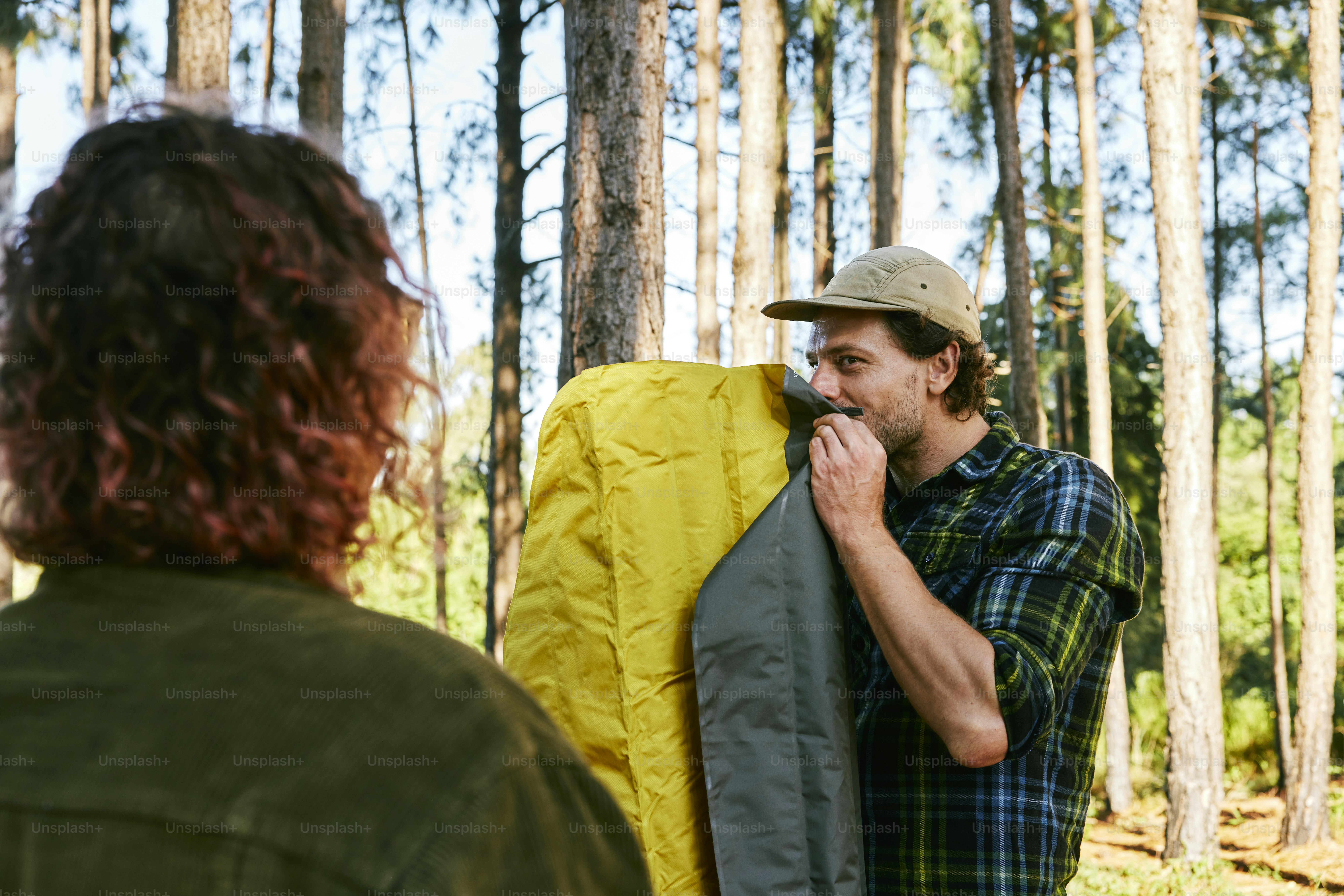 a man standing in the woods with a backpack