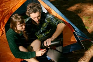 um homem e uma mulher sentados dentro de uma tenda