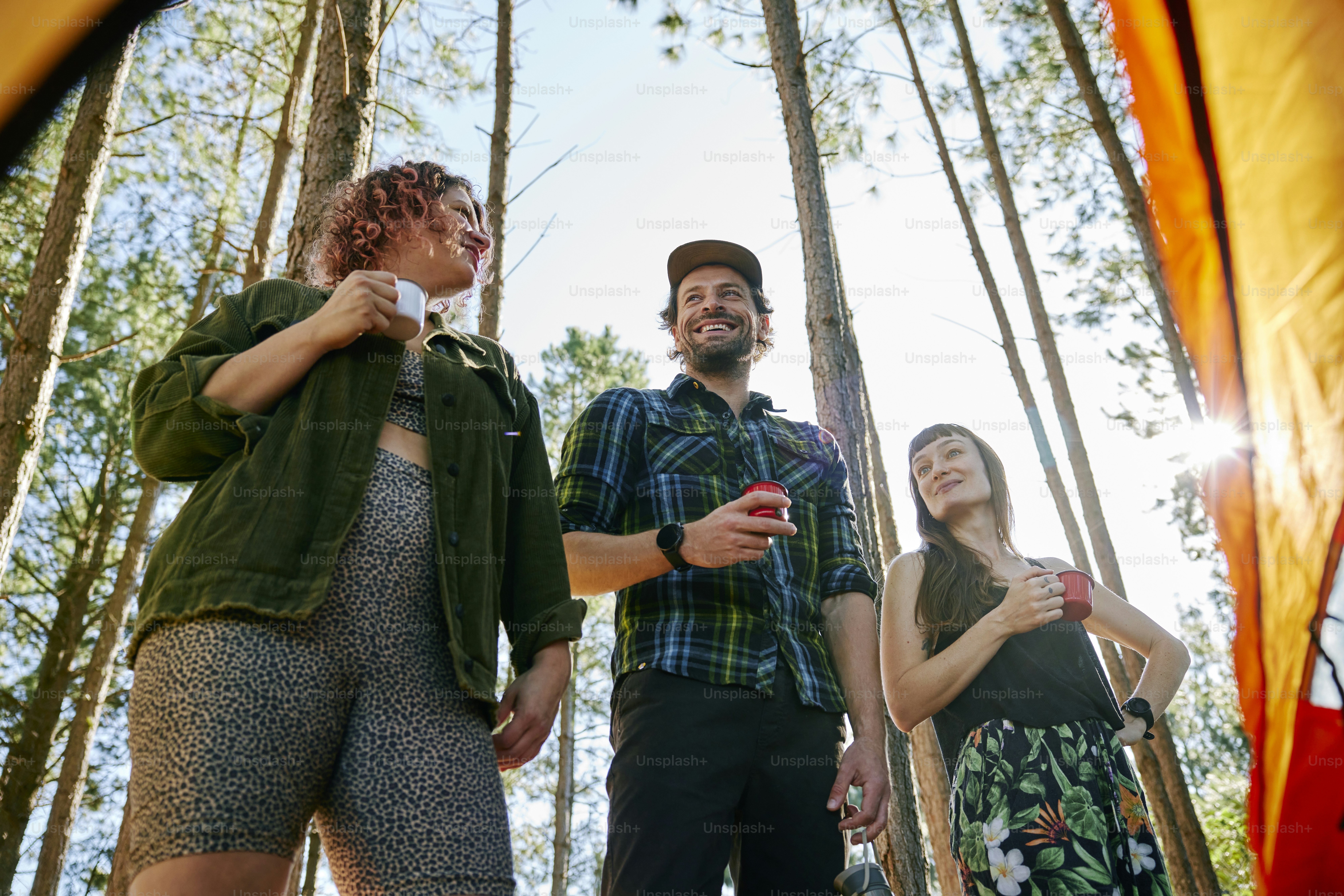A group of people sitting on the ground in the woods photo – Outdoor ...
