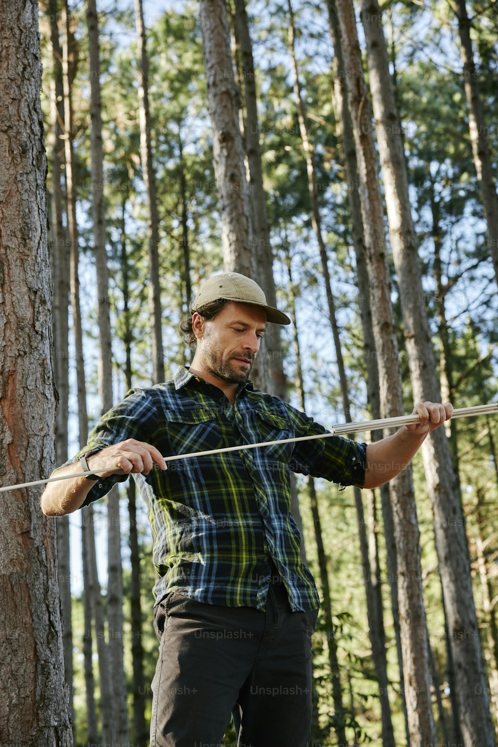 Un uomo che tiene un bastone in una foresta