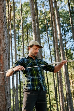 a man holding a stick in a forest