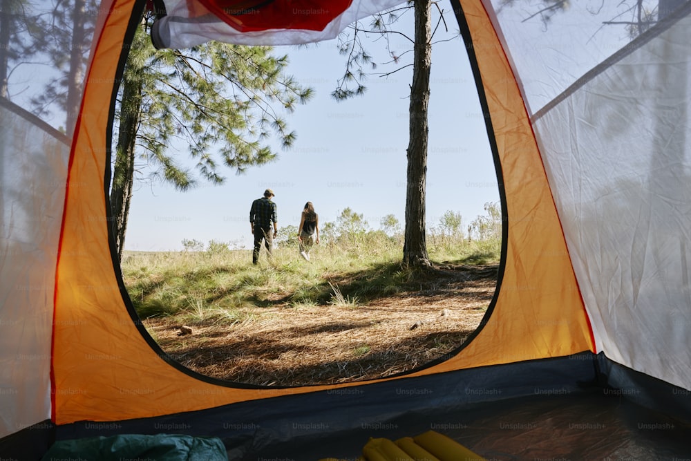 um homem e uma mulher estão de pé em uma tenda
