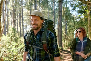 a man and a woman hiking in the woods