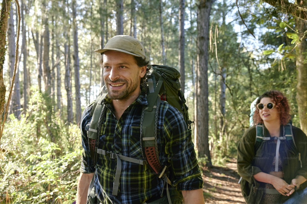 a man and a woman hiking in the woods