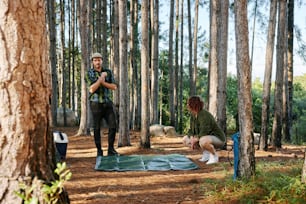 a man and a woman sitting in the woods