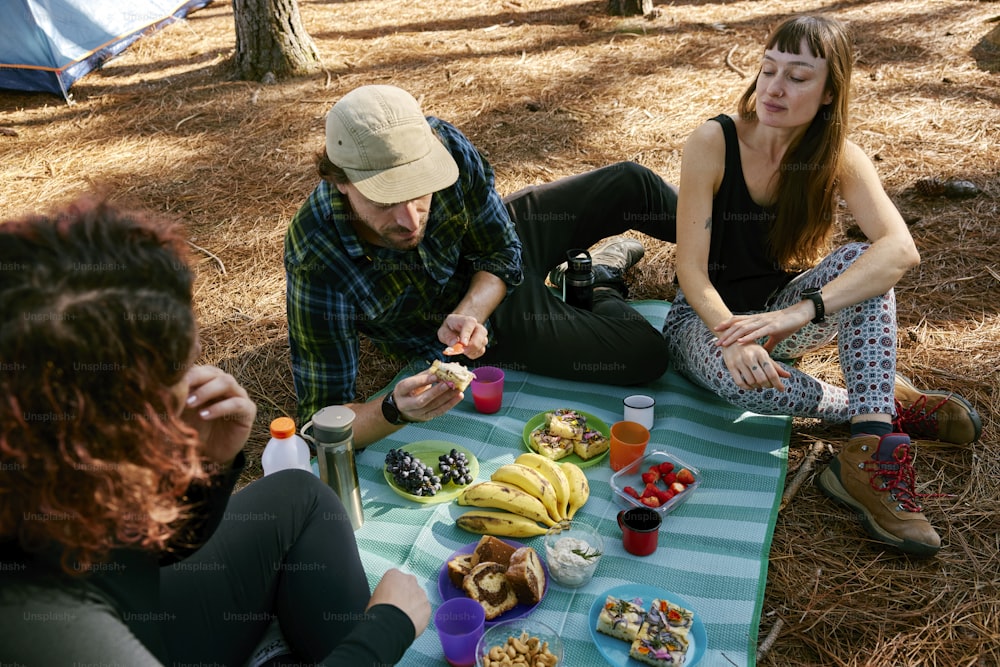 Eine Gruppe von Leuten, die um einen Tisch mit Essen sitzen
