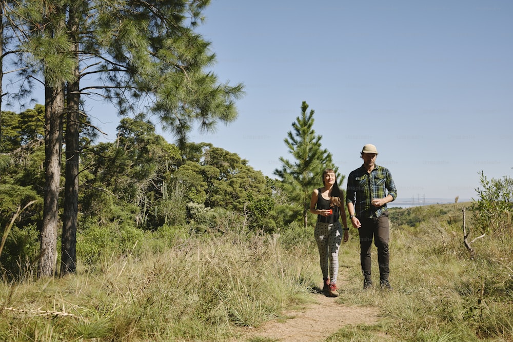 a man and a woman are walking through the woods