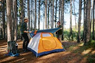 Zwei Männer stehen neben einem Zelt im Wald