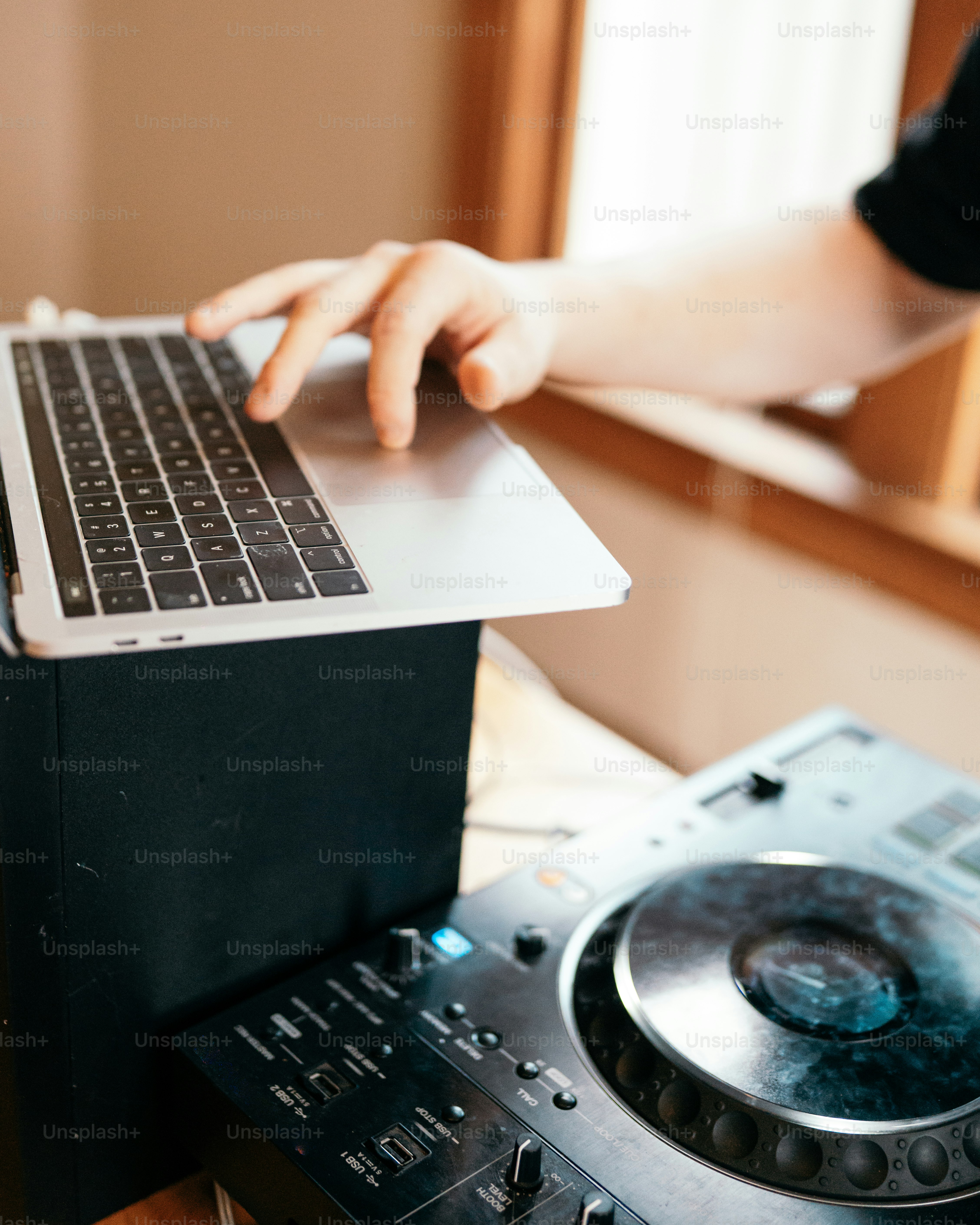 A person using a laptop on top of a turntable photo – Mixing console ...