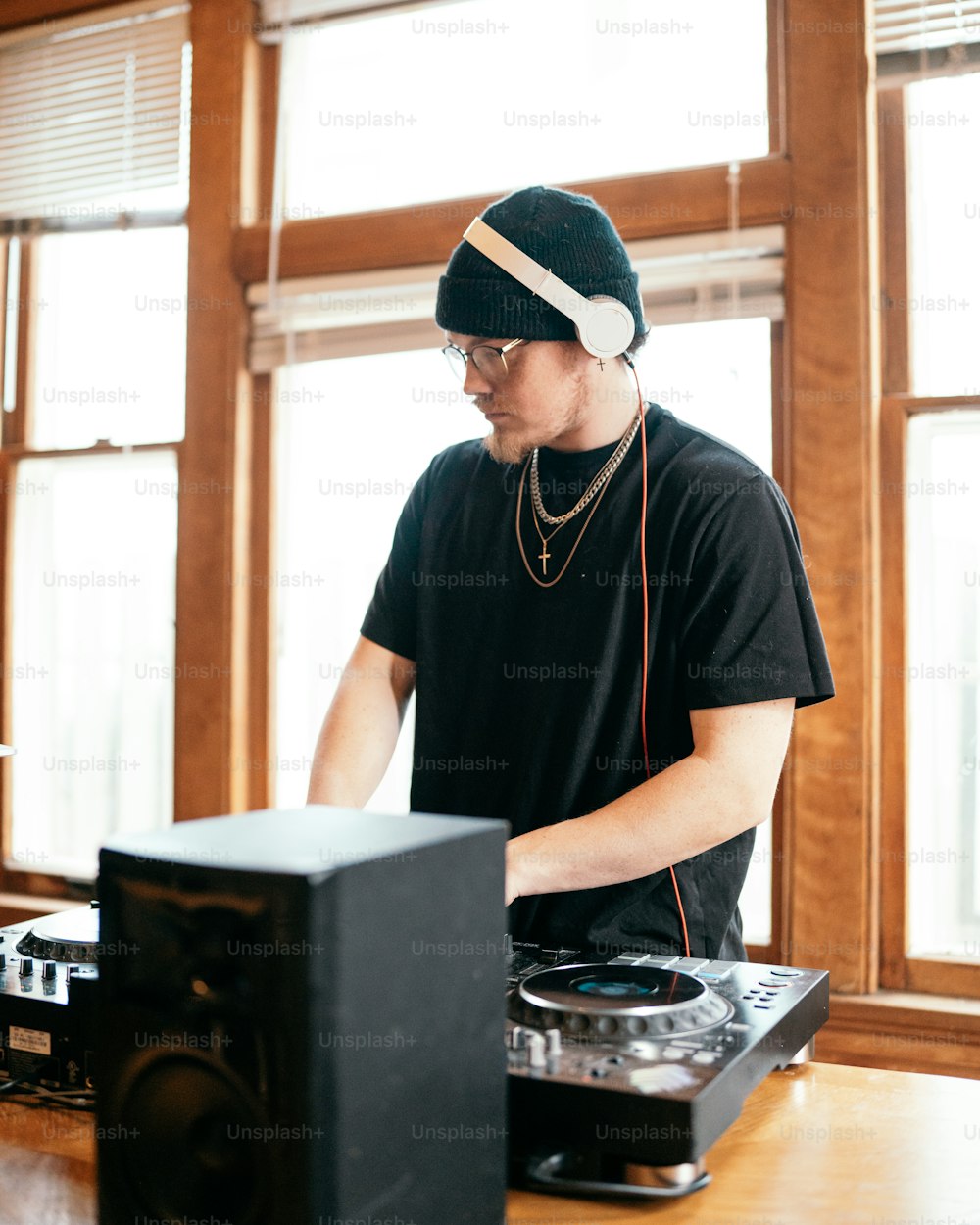 a man in a black shirt and headphones is playing music on a turntable