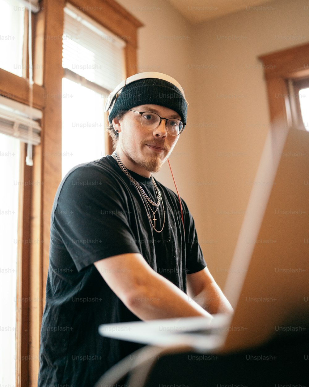 a man in a beanie is using a laptop