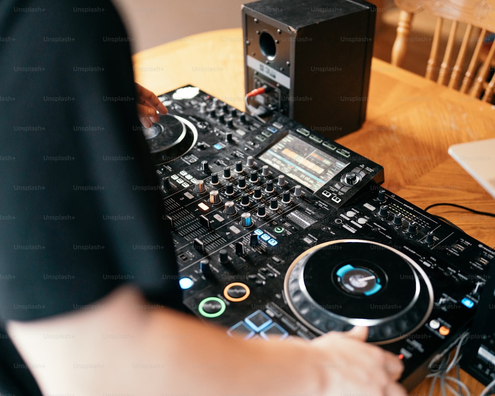 Un DJ mezclando música en una mesa de madera