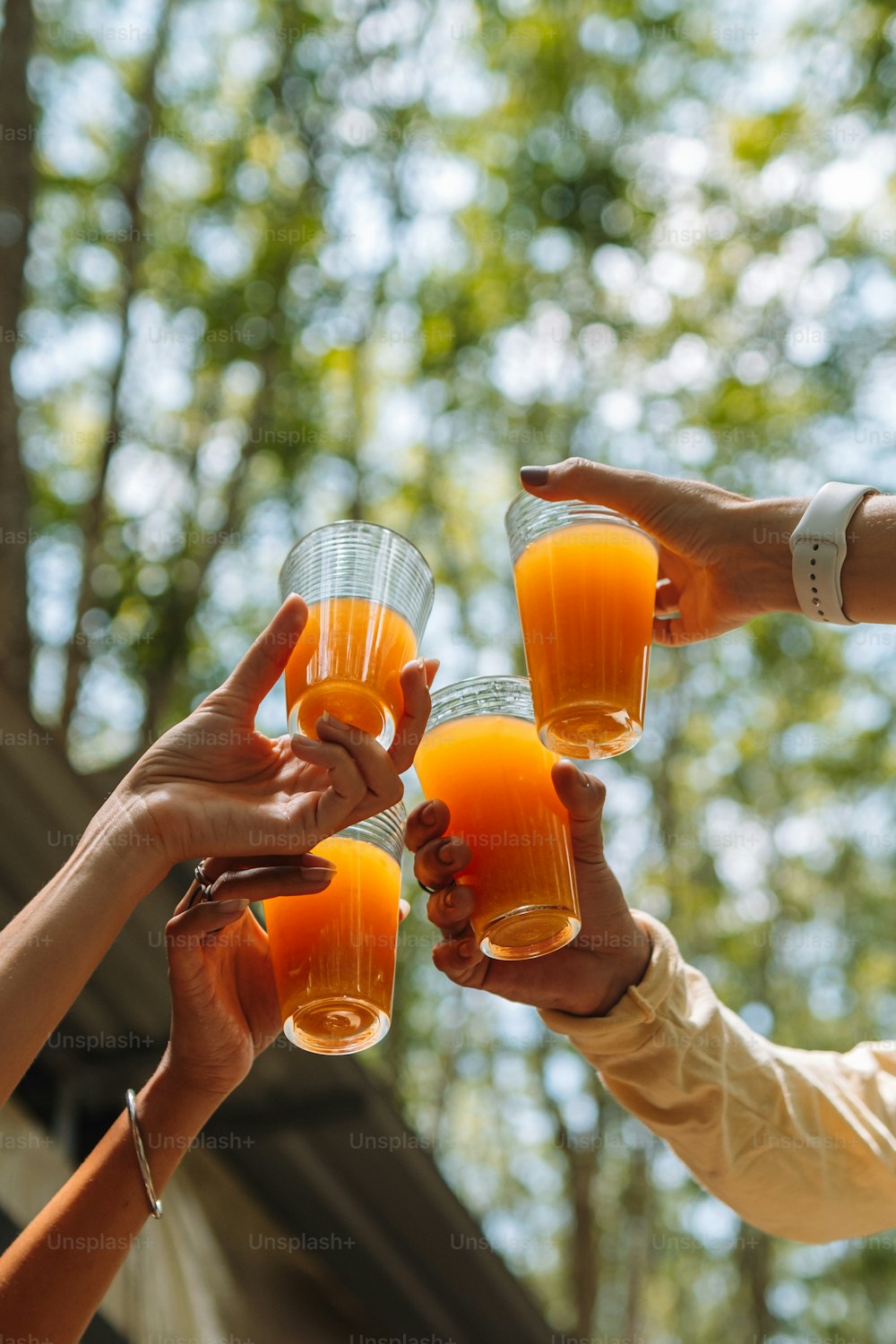 um grupo de pessoas segurando copos de suco de laranja