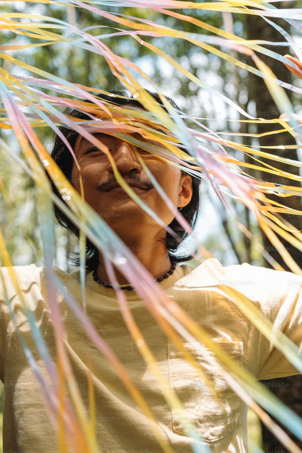 a man standing under a bunch of colorful streamers