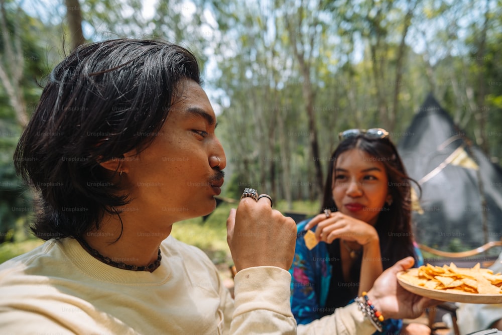a man and a woman eating food from a plate