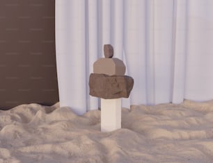 Una escultura de una persona sentada en una roca en la arena