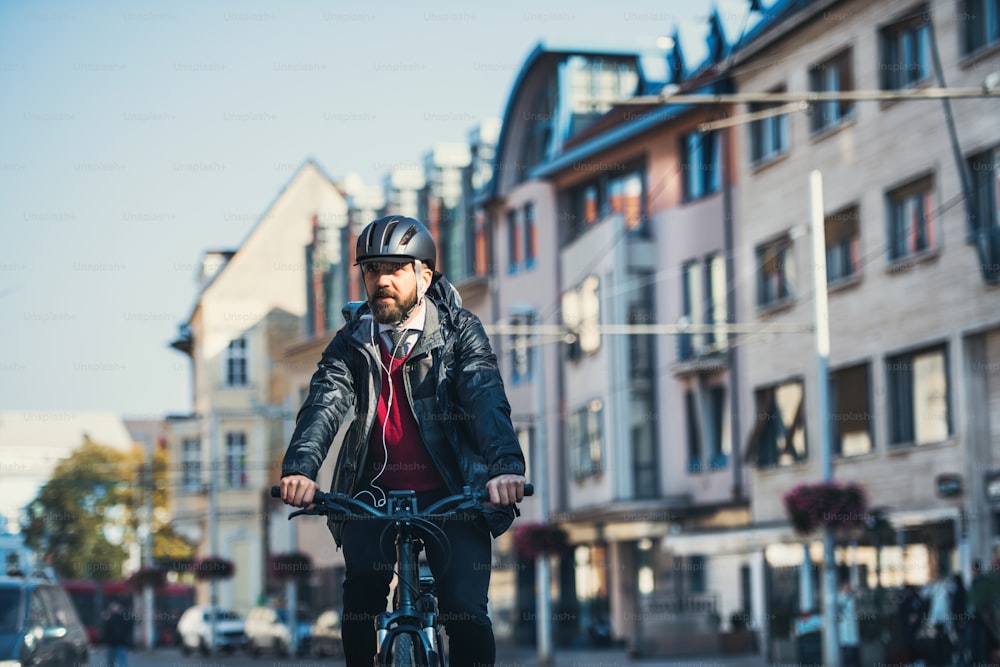 Hipster businessman commuter with electric bicycle traveling home from work in city. Copy space.