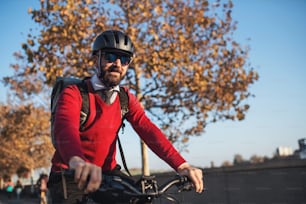 Hipster businessman commuter with bicycle traveling to work in city. Copy space.