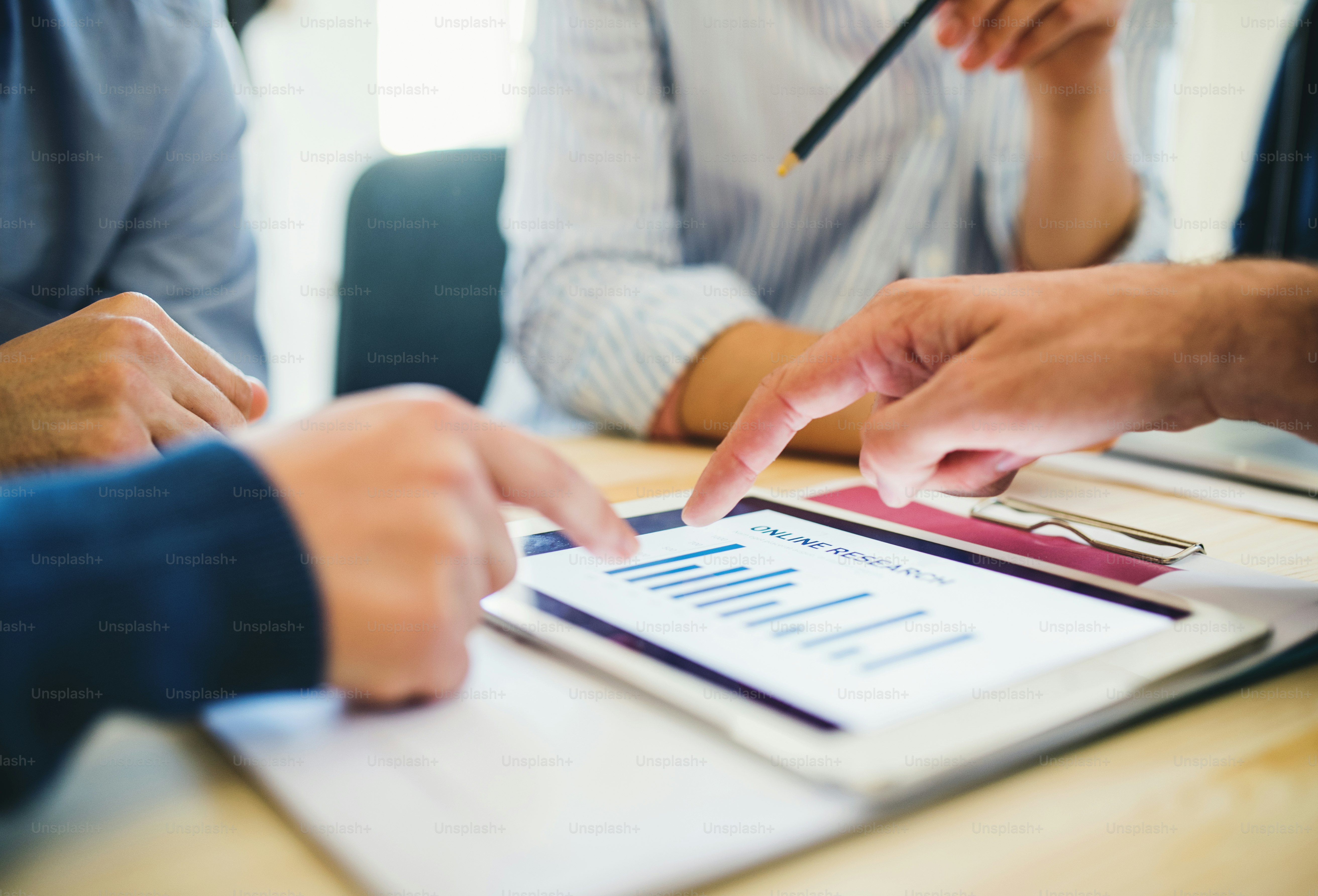 Grupo de empresarios con tableta trabajando juntos en la oficina, una vista de sección media.