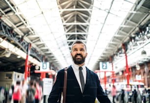 Waist-up portrait of businessman standing inside bus station in London.