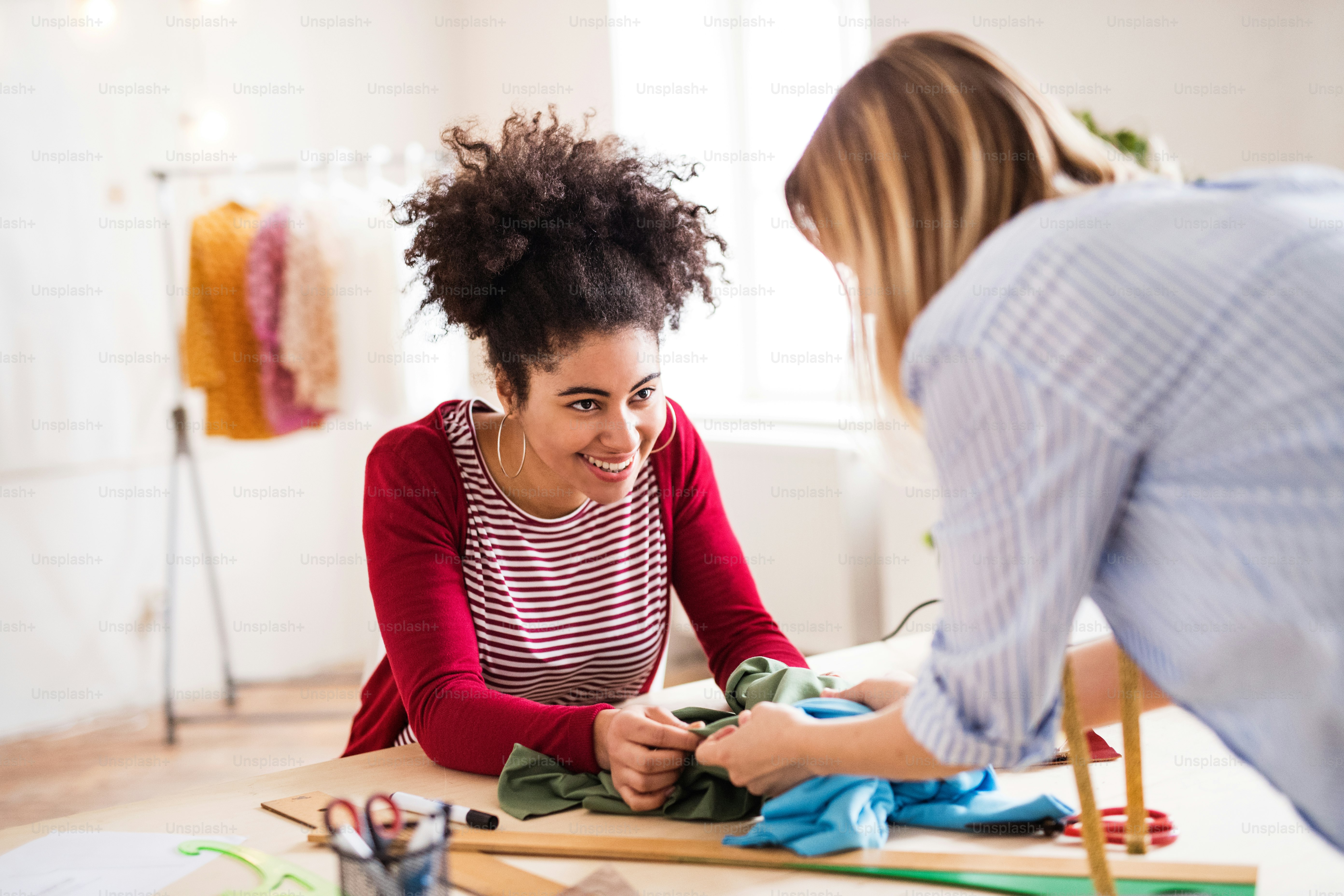 Young creative women with laptop and smartphone working in a studio ...