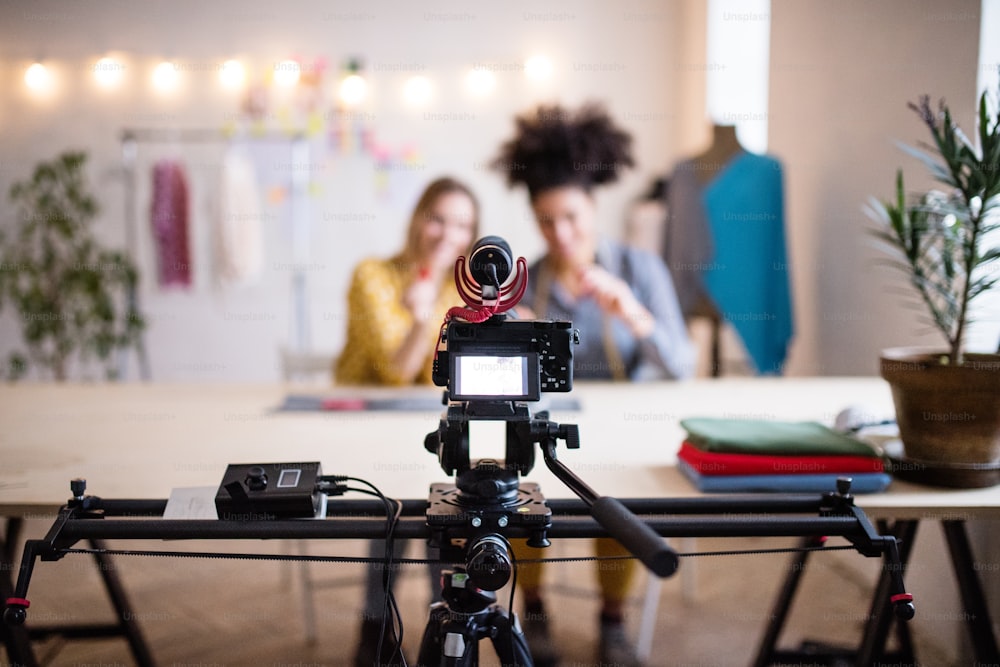 Una cámara con un control deslizante. Mujeres creativas irreconocibles en un estudio. Startup business.