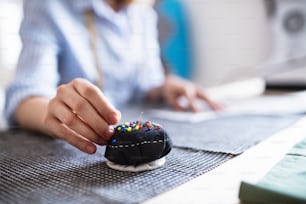 Nicht wiederzuerkennende junge kreative Frau, die in einem Studio, einem Startup-Unternehmen arbeitet.