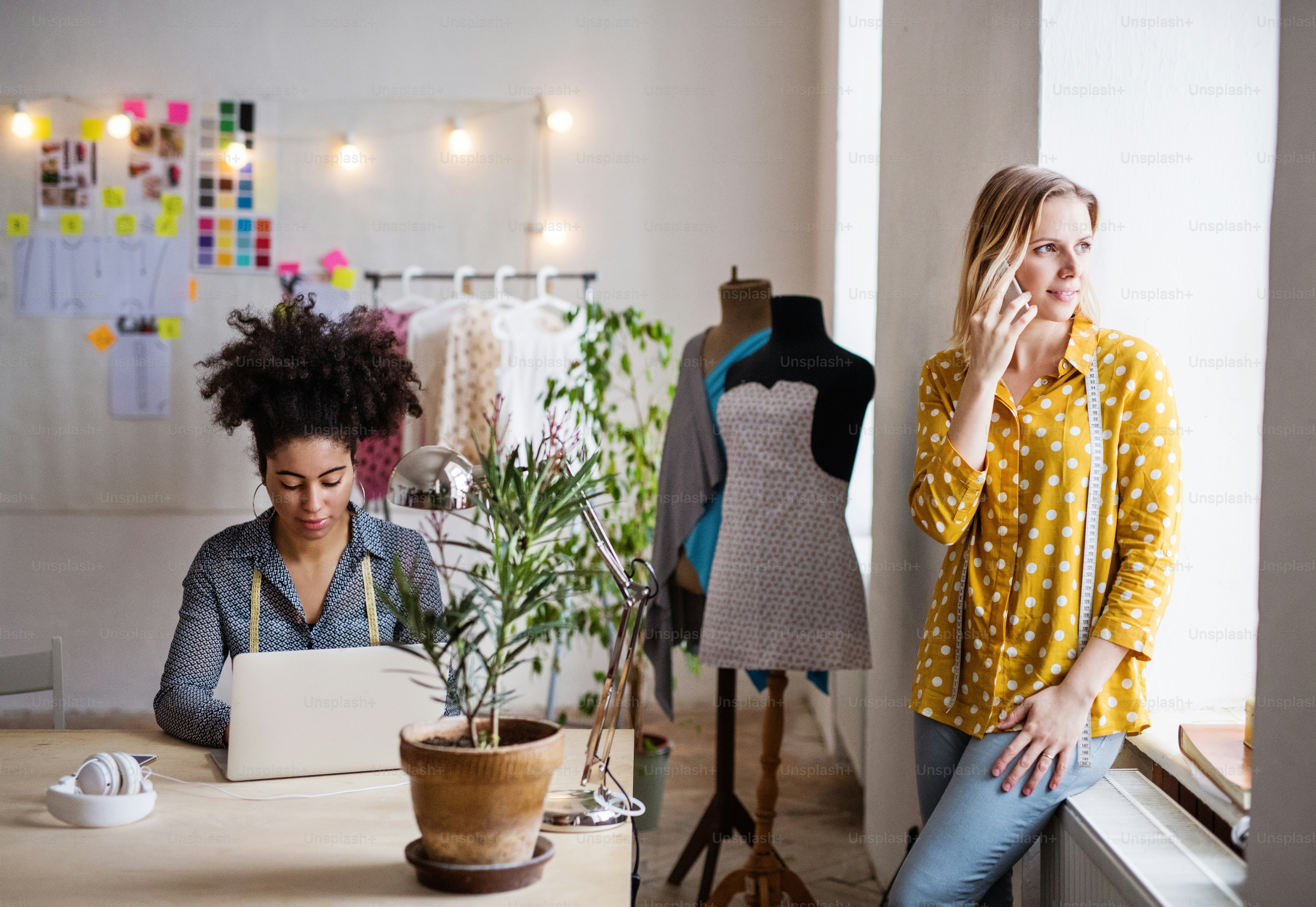 Wanita muda kreatif dengan laptop dan smartphone bekerja di studio, bisnis startup
