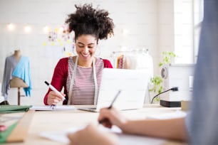 Young creative women with laptop working in a studio, startup business.