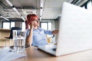 Beautiful businesswoman with laptop in her office.