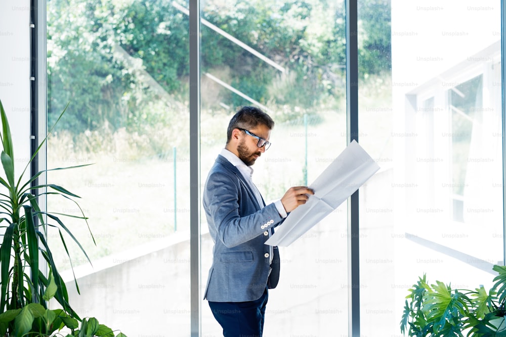 Handsome young businessman in his office studying plans.