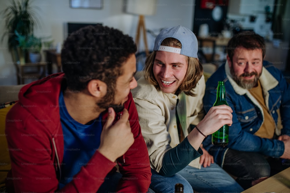 Happy football fans friends watching a football at home and talking