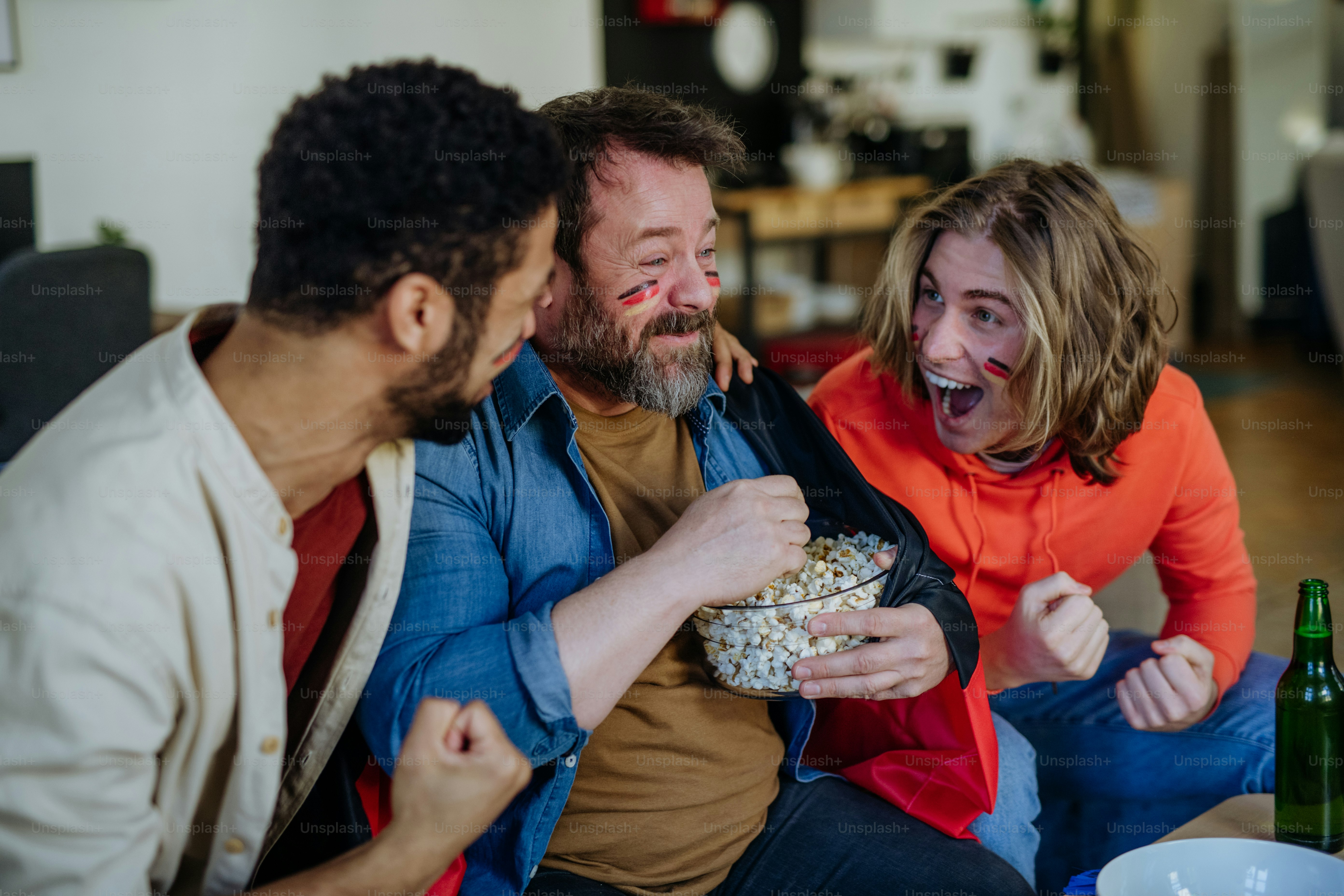 happy-german-football-fans-friends-watching-football-at-home-and-eating