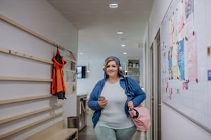 체육관으로 가는 길에 복도에서 실내에서 운동복을 입은 행복한 과체중 여성