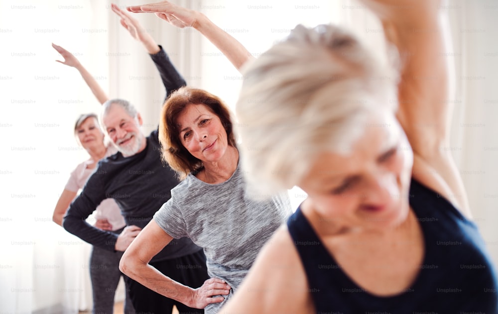 Grupo de personas mayores activas haciendo ejercicio en el club del centro comunitario.