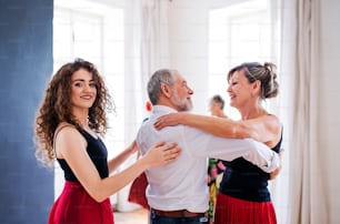 Un groupe de personnes âgées assistant à un cours de danse avec un professeur de danse.