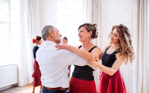 Un groupe de personnes âgées assistant à un cours de danse avec un professeur de danse.