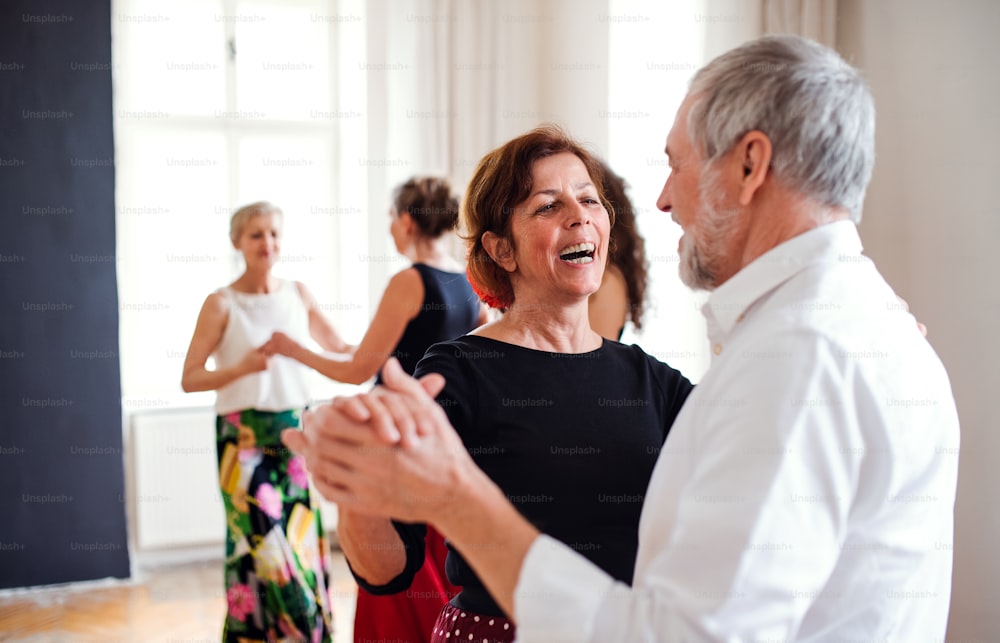 Eine Gruppe älterer Leute, die einen Tanzkurs mit Tanzlehrer besuchen.