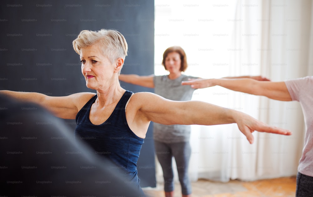 Grupo de personas mayores activas haciendo ejercicio en el club del centro comunitario.