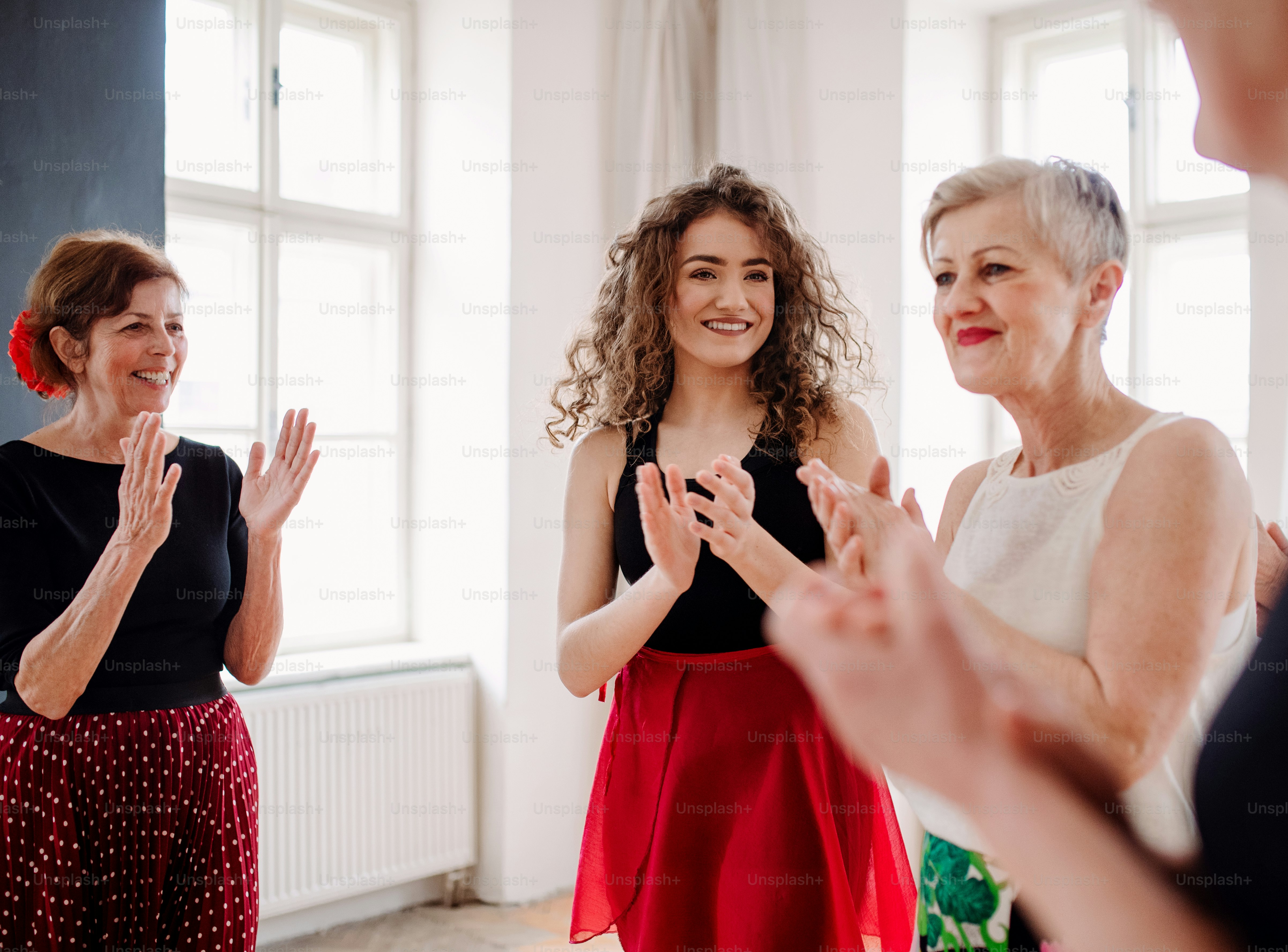 A group of senior women attending dancing class with dance teacher.