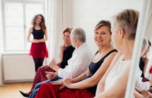 Um grupo de pessoas idosas que frequentam a aula de dança com o professor de dança.