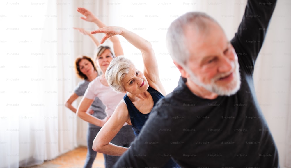 Grupo de personas mayores activas haciendo ejercicio en el club del centro comunitario.