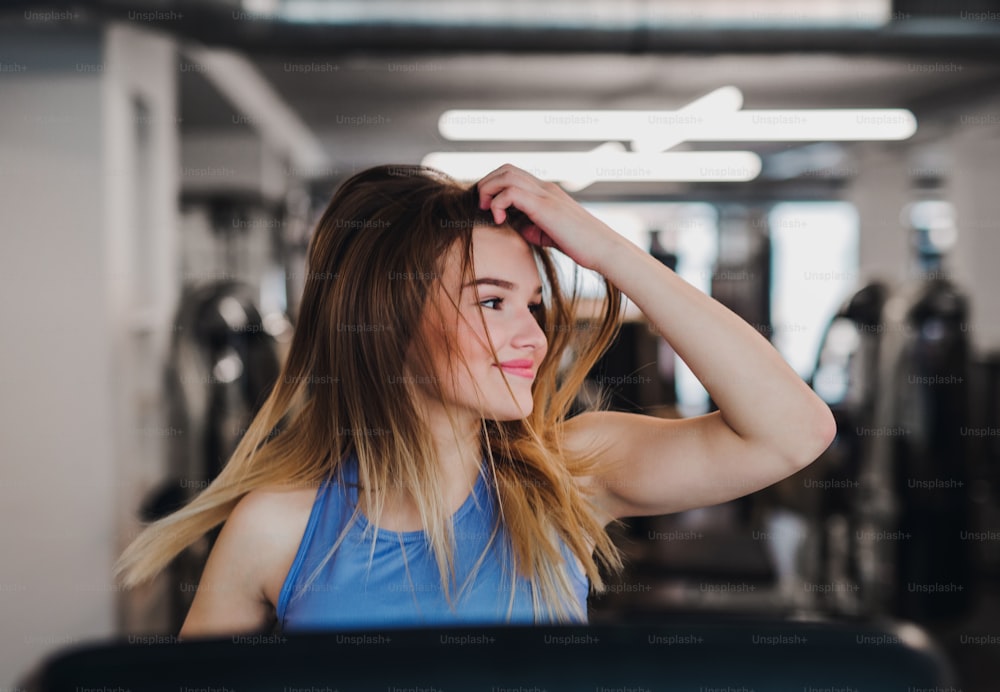 Un retrato de una hermosa niña o mujer haciendo ejercicio cardiovascular en un gimnasio.