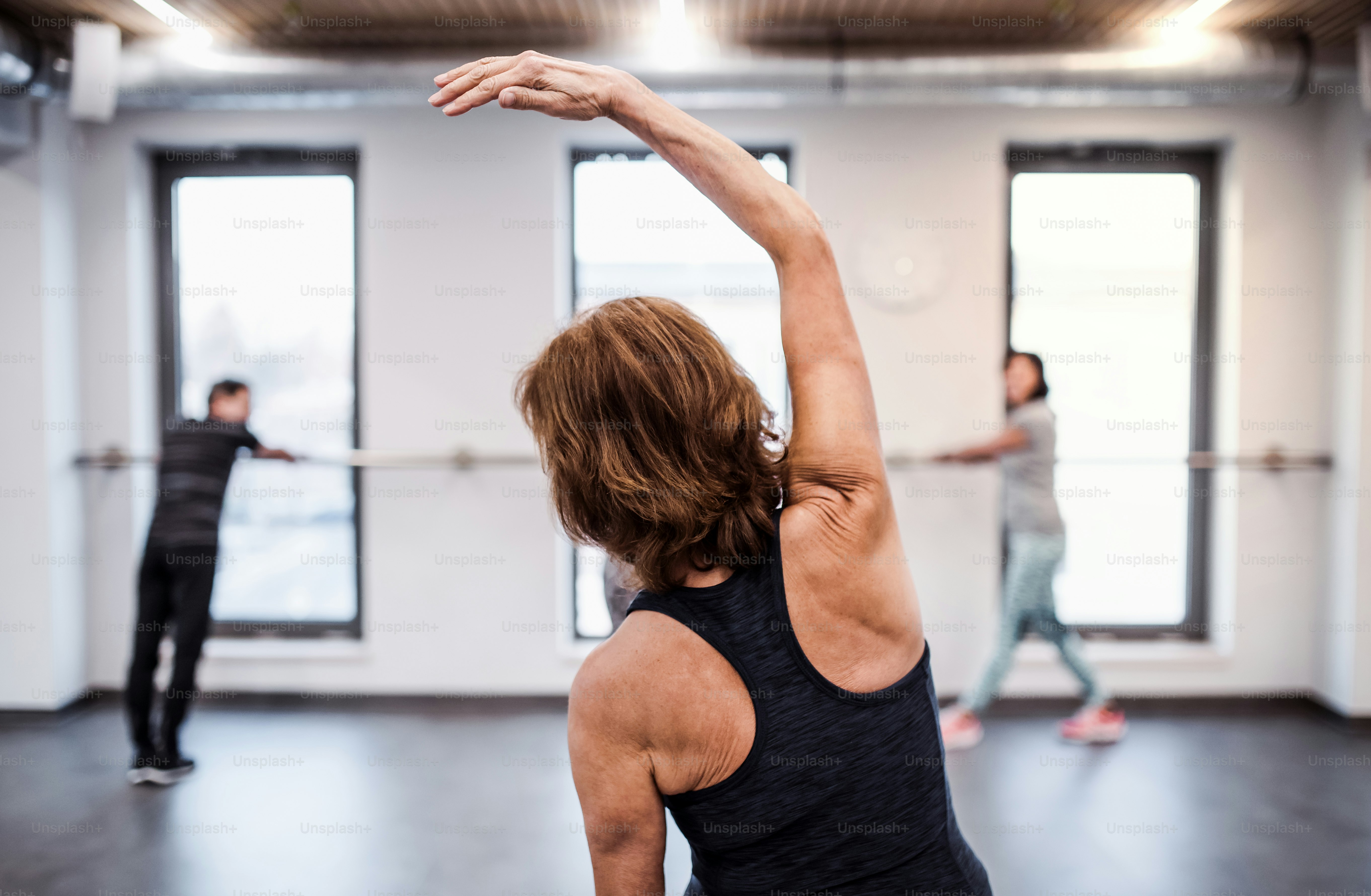 A rear view of active senior woman in gym doing exercise. Copy space.